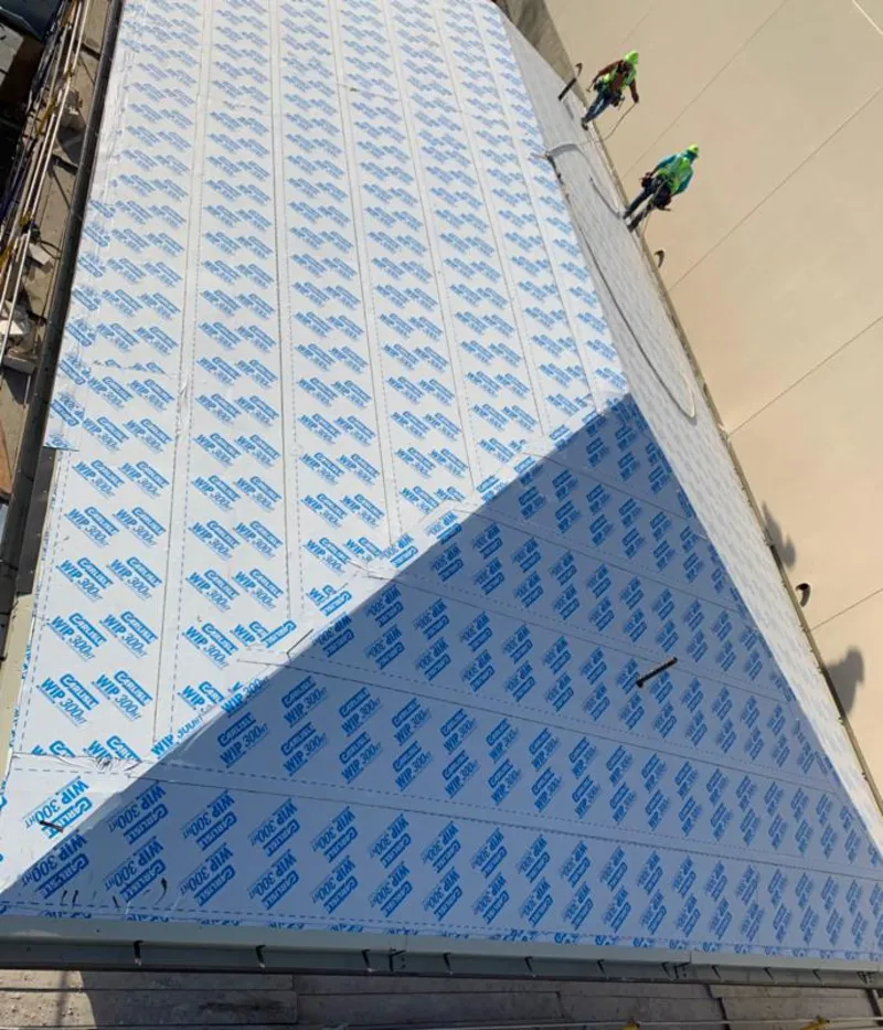 Professional roofers installing underlayment on a metal roof in Catalina Foothills